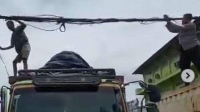 Anggota polisi bantu memperbaiki kabel listrik yang semrawut